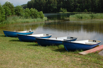 Old Rowboat on a lake in Belarus, summer 2016, four boats on a beach, rent a boats