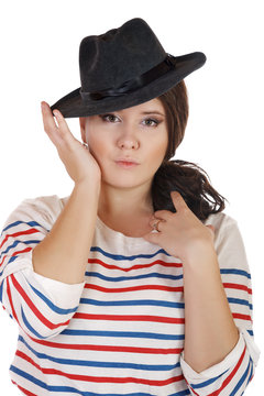 buxomy serious girl with a hat on a white background.