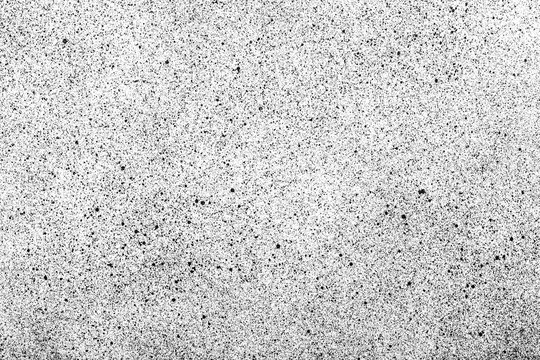 Abstract closeup black spray dots paint on white paper.