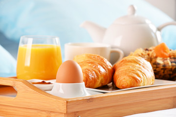 Breakfast on tray in bed in hotel room