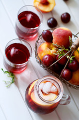 Iced fruit compote with peaches and plums. Cold summer drink.