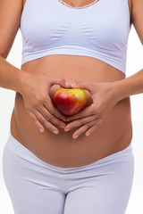 Pregnant woman holding an apple. Vitamins and healthy food during pregnancy