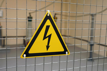 Sign of electrical hazards are yellow with black lightning