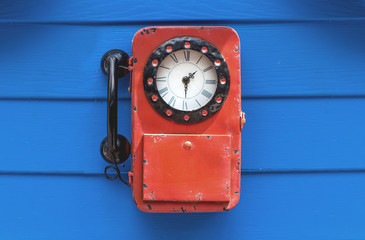 Vintage clock in telephone style hang on the blue wall