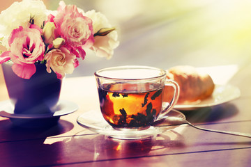 Cup of tea with croissants on table