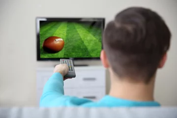 Foto op Plexiglas Man watching football game on tv at home. © Africa Studio