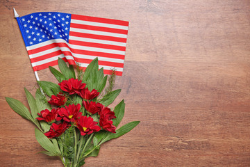 Obraz premium Flowers and American flag on a wooden background