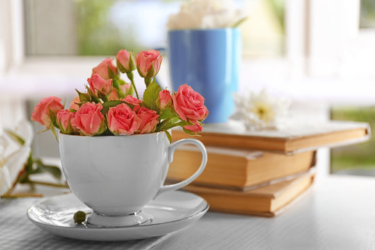 Bouquet of beautiful roses in a cup on a  tablecloth