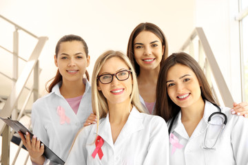 Beautiful female doctors with pink ribbon. Breast cancer concept
