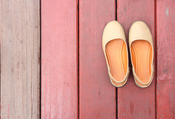 girl shoes over wooden deck floor.