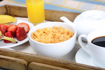 Breakfast tray with coffee, orange juice, cereals and fruits.