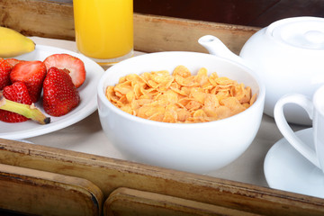 Breakfast tray with coffee, orange juice, cereals and fruits.
