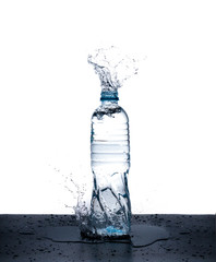 bottle of drinking water splashing out isolated on white