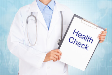 Doctor holding clipboard with health check text on a sheet of paper on white background