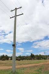 power poles and power lines in a blue cloudy sky