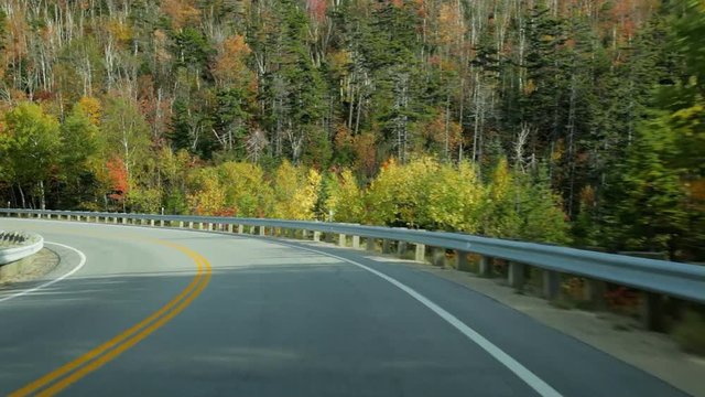 Driving POV on Kancamagus Highway (aka  Kanc Highway) in autumn in the White Mountains of New Hampshire.