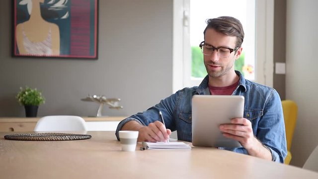 man at home working on digital tablet