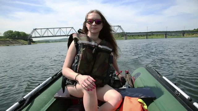 girl in lifejacket controlled boat with outboard engine