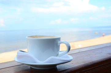 Close up of coffee cup on cafe terrace and the view on the sea in sunny  day. Concept for relax,...