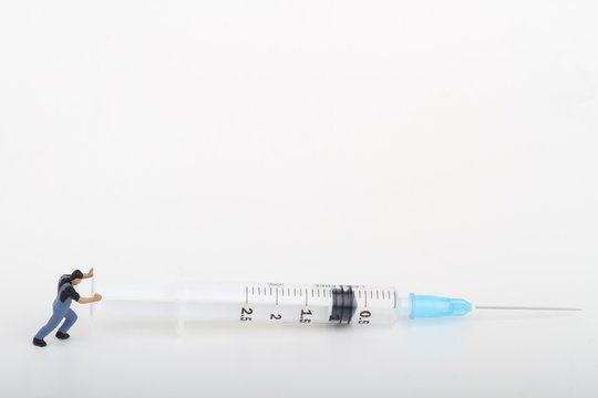 miniature di tossicodipendente che spinge una siringa