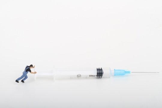 miniature di tossicodipendente che spinge una siringa