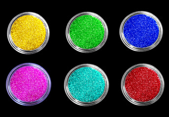 Set of colorful sparkling eye shadows in jars isolated on black  background