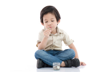 Cute Asian child saving money in glass bottle