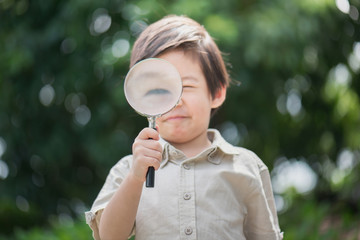 Asian boy with magnifying glass