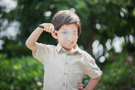 Asian boy with magnifying glass