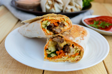 Shawarma - Middle East (Arabic) dish of pita (lavash) stuffed with: grilled meat, sauce, vegetables