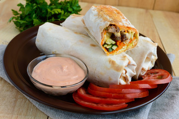 Shawarma - Middle East (Arabic) dish of pita (lavash) stuffed with: grilled meat, sauce, vegetables