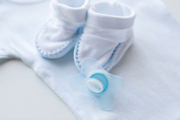 close up of soother and baby clothes for newborn