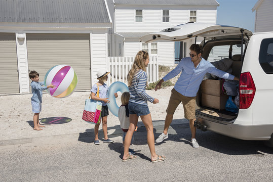 Young family packing car with beach gears for vacation