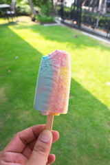 Rainbow ice cream with hand