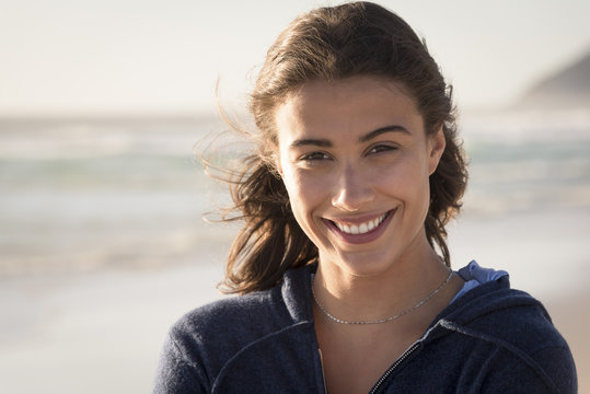 Fototapeta Portrait of a happy beautiful young woman on the beach