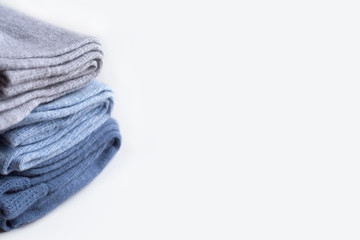A pile of gray, light cornflower blue, denim knitwear socks isolated on white background. 