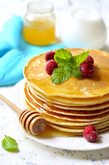 Homemade pancakes with honey and raspberry.