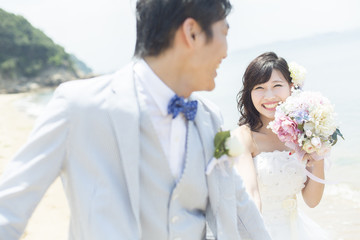 ビーチを走る新郎新婦
