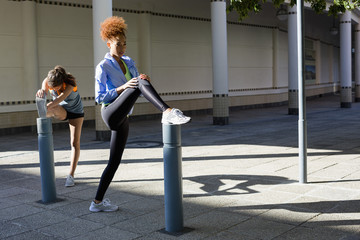 Two women stretching in urban setting
