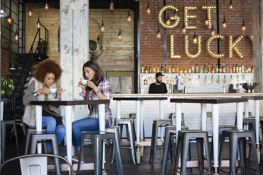 Two Women Drinking Coffee In Cafe