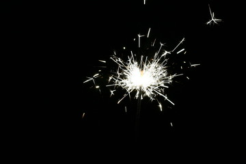 Photograph of the sparkler with bright sparks on a black background