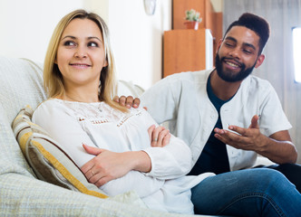 Indoors portrait of mixed couple trying to reconcile after quarr