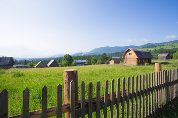 wooden houses on a grass hills