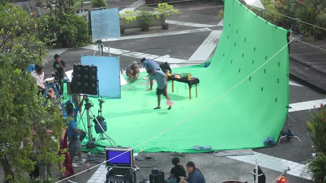 BANGKOK THAILAND - DECEMBER 3: Group of people make advertising and set up green screen studio outdoor as behind the scene, day to night time lapse in BANGKOK, Thailand on December 3, 2012