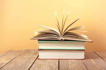 Open book, hardback books on wooden table. Education background. Back to school. Copy space for text.