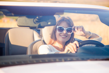 girl driver sits in white cabriolet