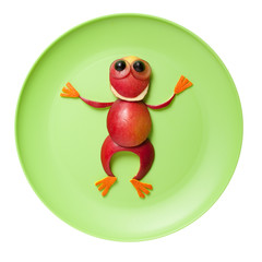 Frog made of red apple on green plate