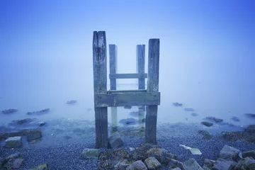 Foto op Plexiglas Jetty in the sea on a foggy morning at dawn © sara_winter