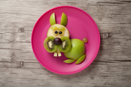 Rabbit made of fruits on plate and board