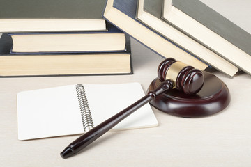 Law concept - Book with wooden judges gavel on table in a courtroom or enforcement office.